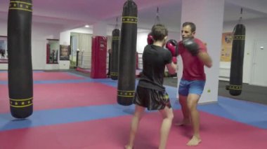 Spor salonunda antrenörü ile yastıkları isabet genç kickboks avcı