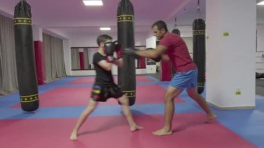 Spor salonunda antrenörü ile yastıkları isabet genç kickboks avcı