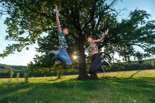 Casal Feliz Pulando Alegria Sob Árvore Enorme — Fotografia de Stock