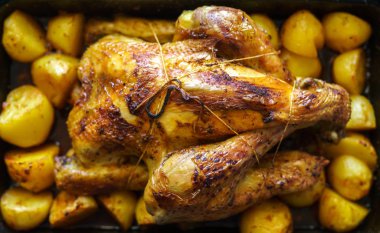 Patates içinde tepsi ile fırında bütün tavuk yavaş pişmiş