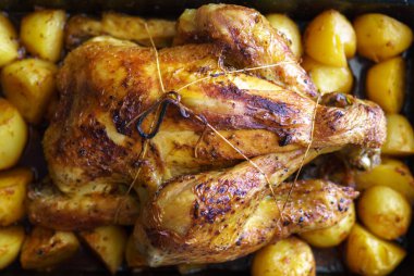 Patates içinde tepsi ile fırında bütün tavuk yavaş pişmiş