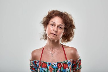 Portre studio gri arka plan üzerinde üzgün olgun bir kadın portresi