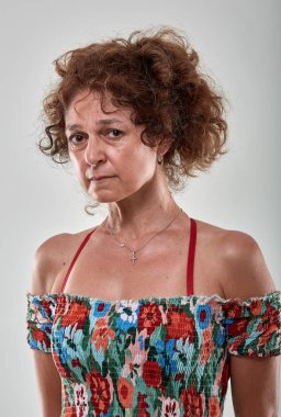 Gri arka plan üzerinde üzgün olgun bir kadın portresi stüdyo