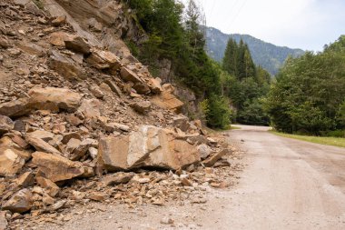 Bir dağ çığ tarafından gündüz kırık asfalt yol