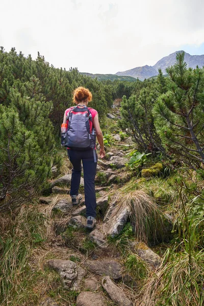 中年女性の昼間の山の道でハイキングのバックパック — ストック写真