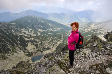 Sırt çantası, gündüz dağlarda buzul Gölü yukarıda bayanla uzun yürüyüşe çıkan kimse