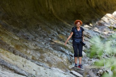 Orta yaşlı kadın hiker gündüz yürüyüş. Dağlarda izinde hiking sırt çantası kadınla