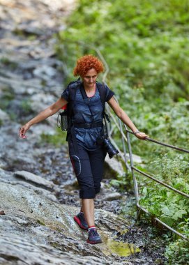 Orta yaşlı kadın hiker gündüz yürüyüş. Dağlarda izinde hiking sırt çantası kadınla
