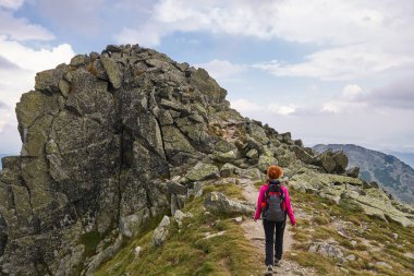 Orta yaşlı kadın hiker gündüz yürüyüş. Dağlarda izinde hiking sırt çantası kadınla