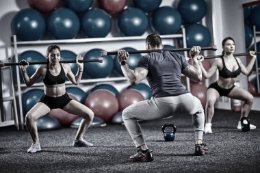 Fitness Eğitmeni ve bacaklar için fitbar egzersiz yapıyor öğrenciler