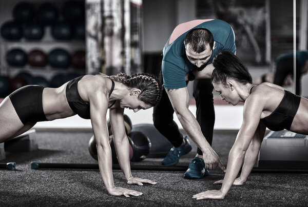 Fitness trainer and girls doing crossfit workout in the gym