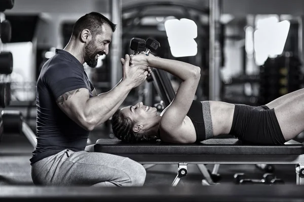 私人教练帮助女性在健身房锻炼三头肌 — 图库照片