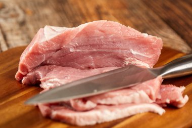 Domuz eti şefin bıçak ve bir ahşap tahta bacakla dilimlenmiş