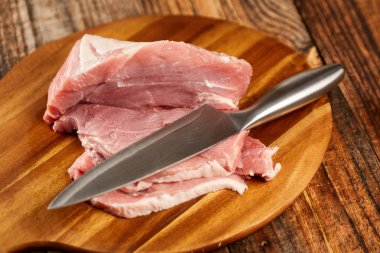 Domuz eti şefin bıçak ve bir ahşap tahta bacakla dilimlenmiş