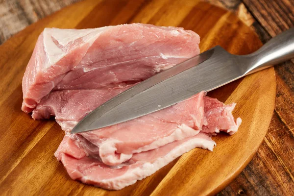 Domuz eti şefin bıçak ve bir ahşap tahta bacakla dilimlenmiş