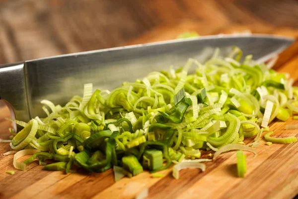 Primer Plano Puerro Picado Una Tabla Madera Una Cocina — Foto de Stock