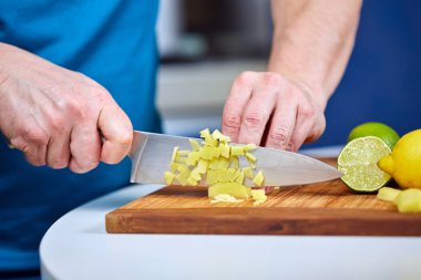 Adam bir tarifi için ahşap bir gemide taze zencefil doğrama closeup