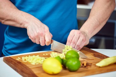 Adam bir tarifi için ahşap bir gemide taze zencefil doğrama closeup