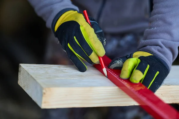 Woodworker measuring and drawing lines on his cabinet project