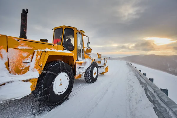 Suuri Traktori Lumilinko Puhdistaa Teitä Vuorilla — kuvapankkivalokuva