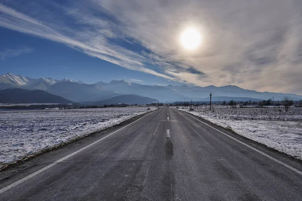 Boş Yol Kış Saati Çerçevesinde Günbatımı Güneş Dağlara Gidiyor — Stok fotoğraf