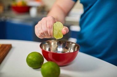 Bir kase içine bir limon sıkma adamın elini