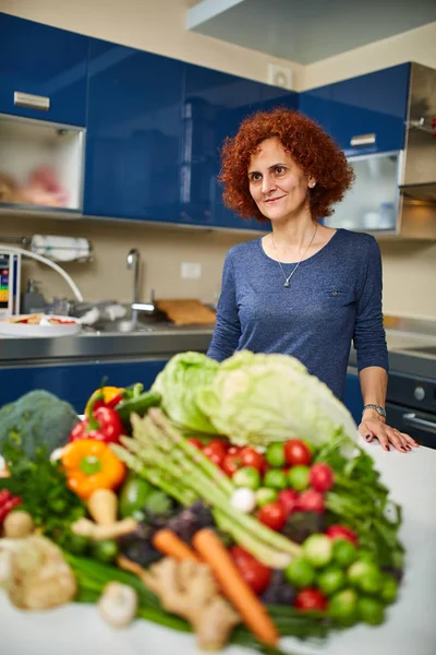 Γυναίκα Ένα Σωρό Λαχανικά Στην Κουζίνα — Φωτογραφία Αρχείου
