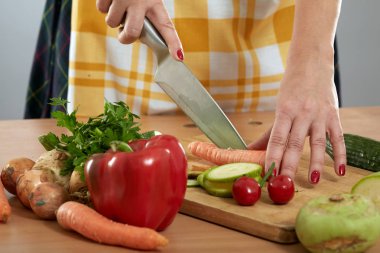 Kadının el ahşap bir gemide çeşitli sebze doğrama