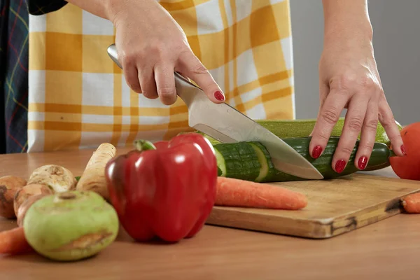 木の板にさまざまな野菜をまな板の女性の手 — ストック写真