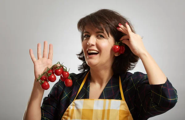 チェリー トマトのつるを保持している女性料理 — ストック写真