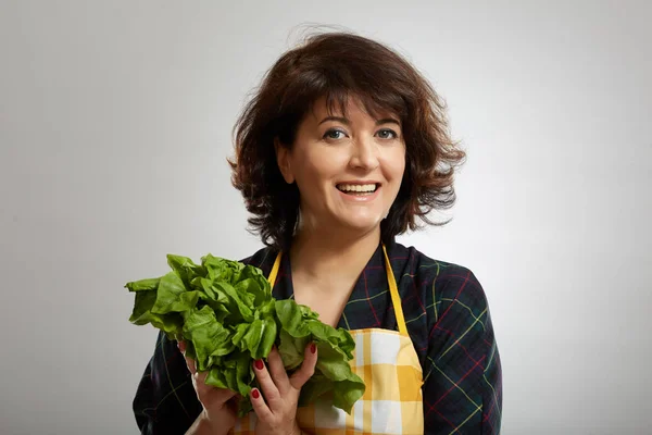 灰色の背景の上に新鮮なレタスを保持している女性料理 — ストック写真