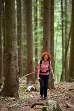 Kıvırcık saçlı kadın izi gündüz hiking sırt çantası ile