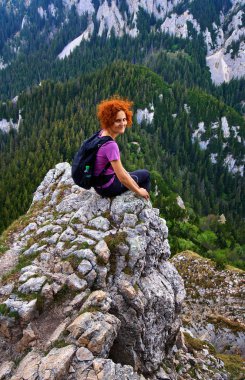 Dağın tepesinde sırt çantası ile mutlu kadın