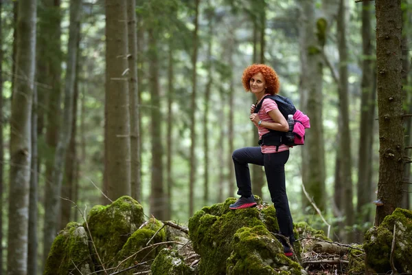 昼間でトレイルのハイキングのバックパックと巻き毛の赤毛の女性 — ストック写真