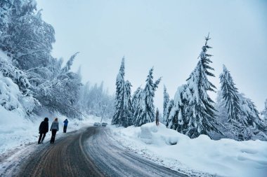 Kış tatili dağlarda karlı yol üzerinde yürüyen insanlar