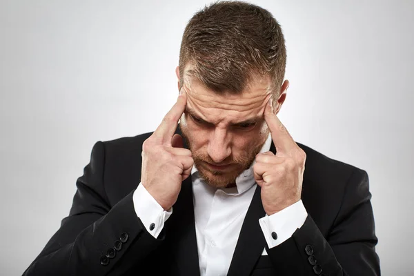 Closeup of a businessman with strong migraine, studio shot