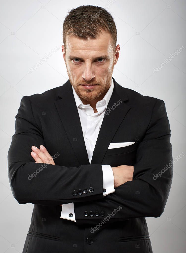Unhappy businessman frowning with arms folded