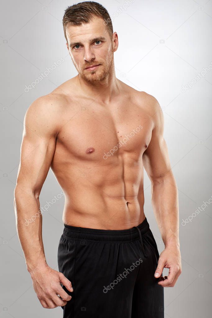 Fitness model portrait on gray background, studio shot