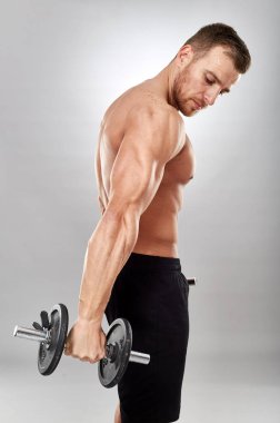 Gri zemin üzerine ağırlıklar ile çalışma dışarı fitness modeli