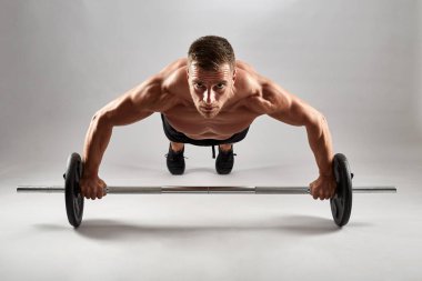 Studio gri arka plan üzerinde şınav fitness modeli