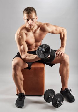 Gri zemin üzerine ağırlıklar ile çalışma dışarı fitness modeli
