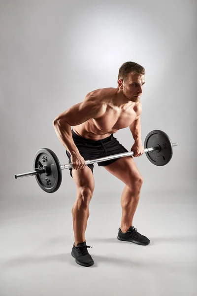 Hombre Haciendo Ejercicio Vuelta Fila Barras Estudio Sobre Fondo Gris — Foto de Stock