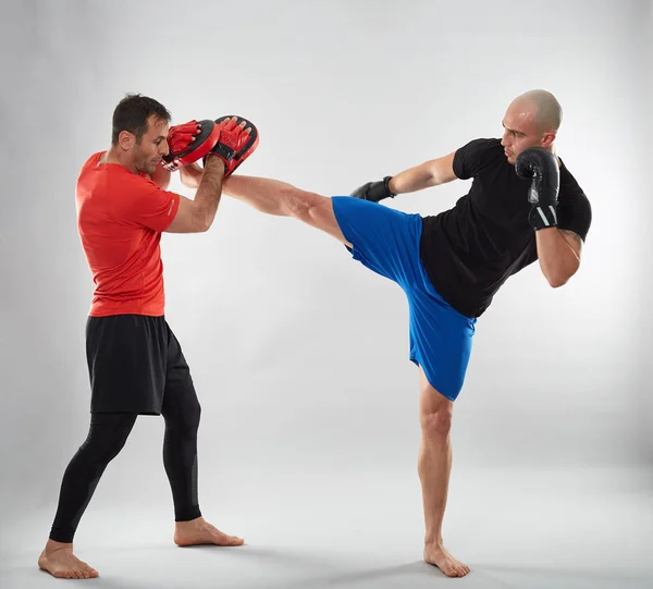 Joven Luchador Kickboxing Golpeando Guantes Con Entrenador Fondo Gris —  Fotos de Stock