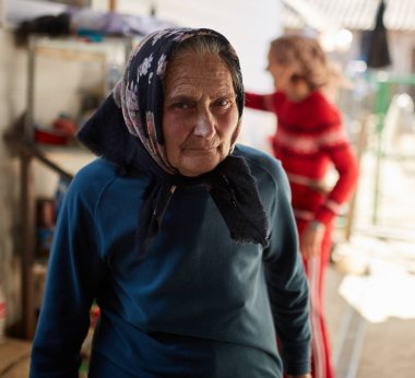 Eski bir kadın çiftçi portresi, kızı arka planda