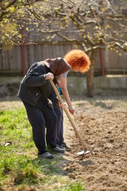 Beyaz kadın çiftçi ve annesi bahçede çalışıyor
