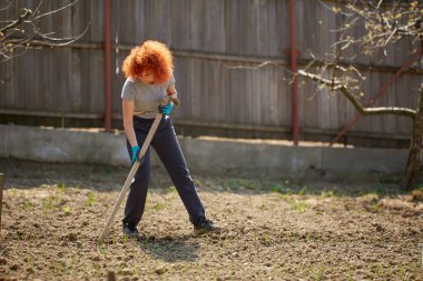 Çapayla bahçe işi yapan bir kadın.