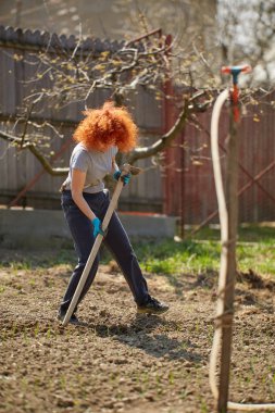 Çapayla bahçe işi yapan bir kadın.