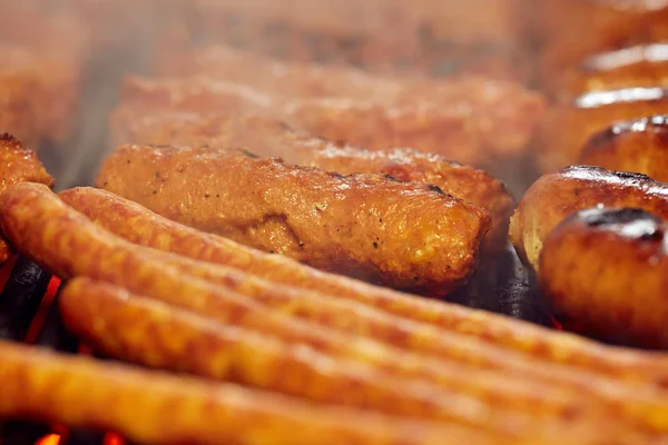 香肠和肉卷在烤架上的特写 — 图库照片