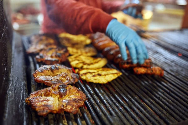 屋外で様々な肉を焼く正体不明の料理人 — ストック写真