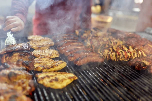 屋外で様々な肉を焼く正体不明の料理人 — ストック写真